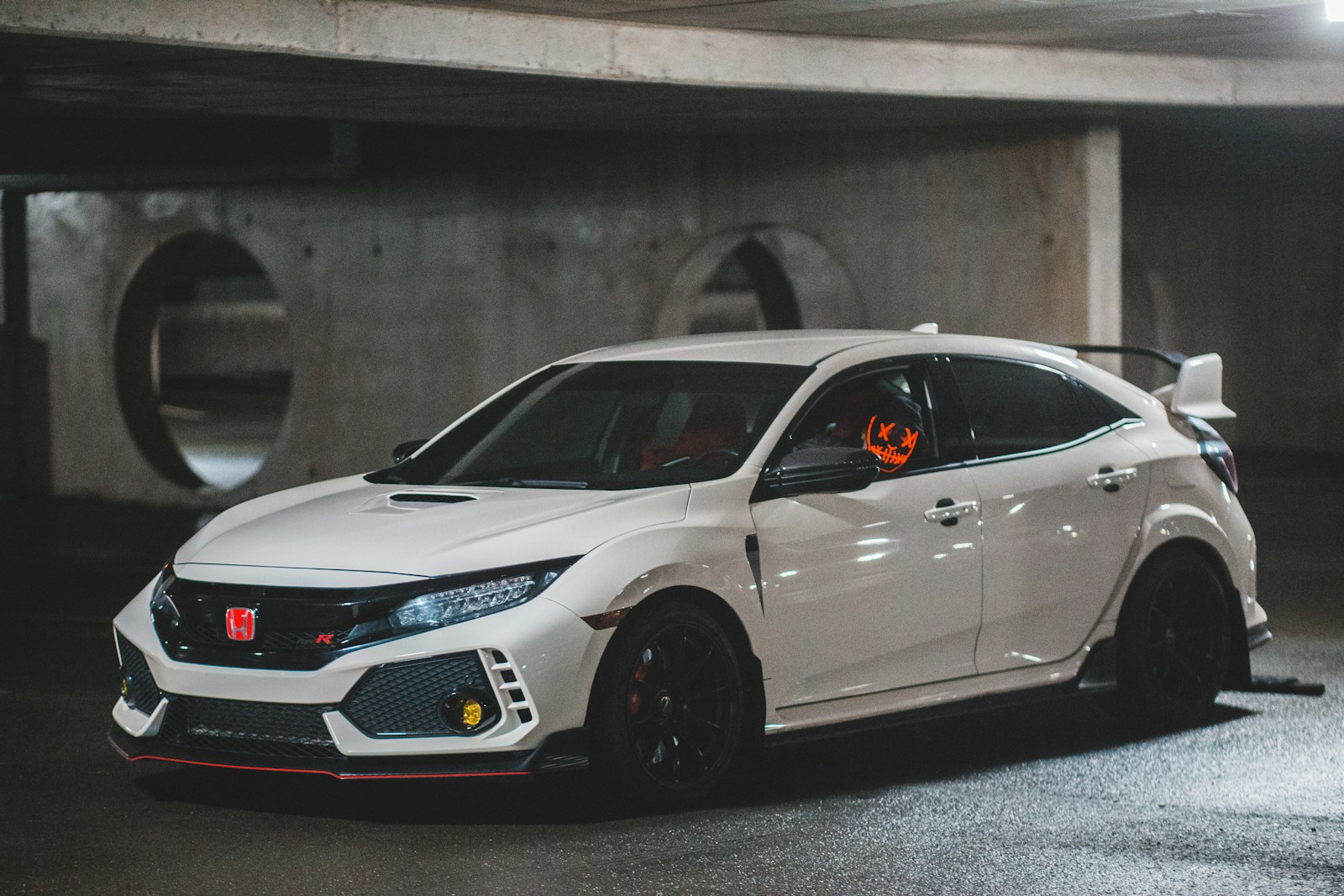 White Honda Civic Type R hatchback parked beside a concrete building