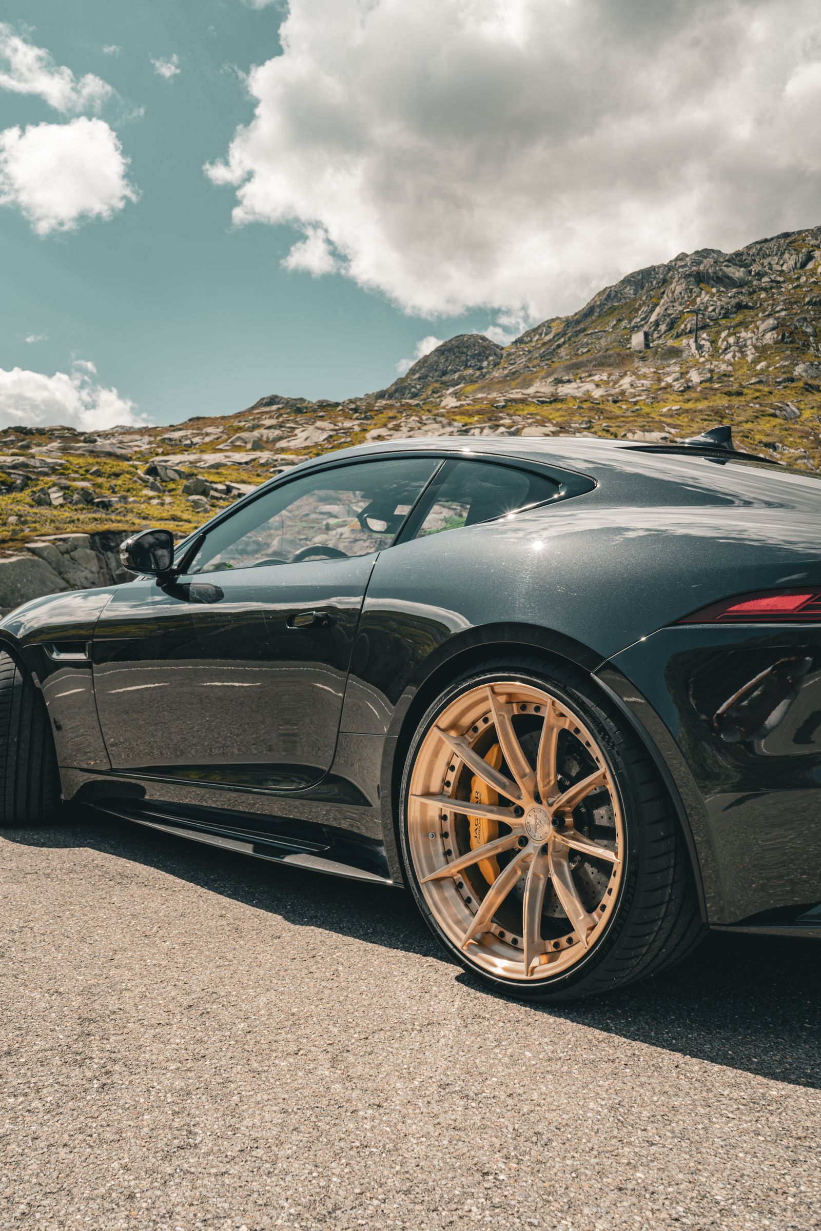 Jaguar deportivo negro aparcado en una carretera de montaña