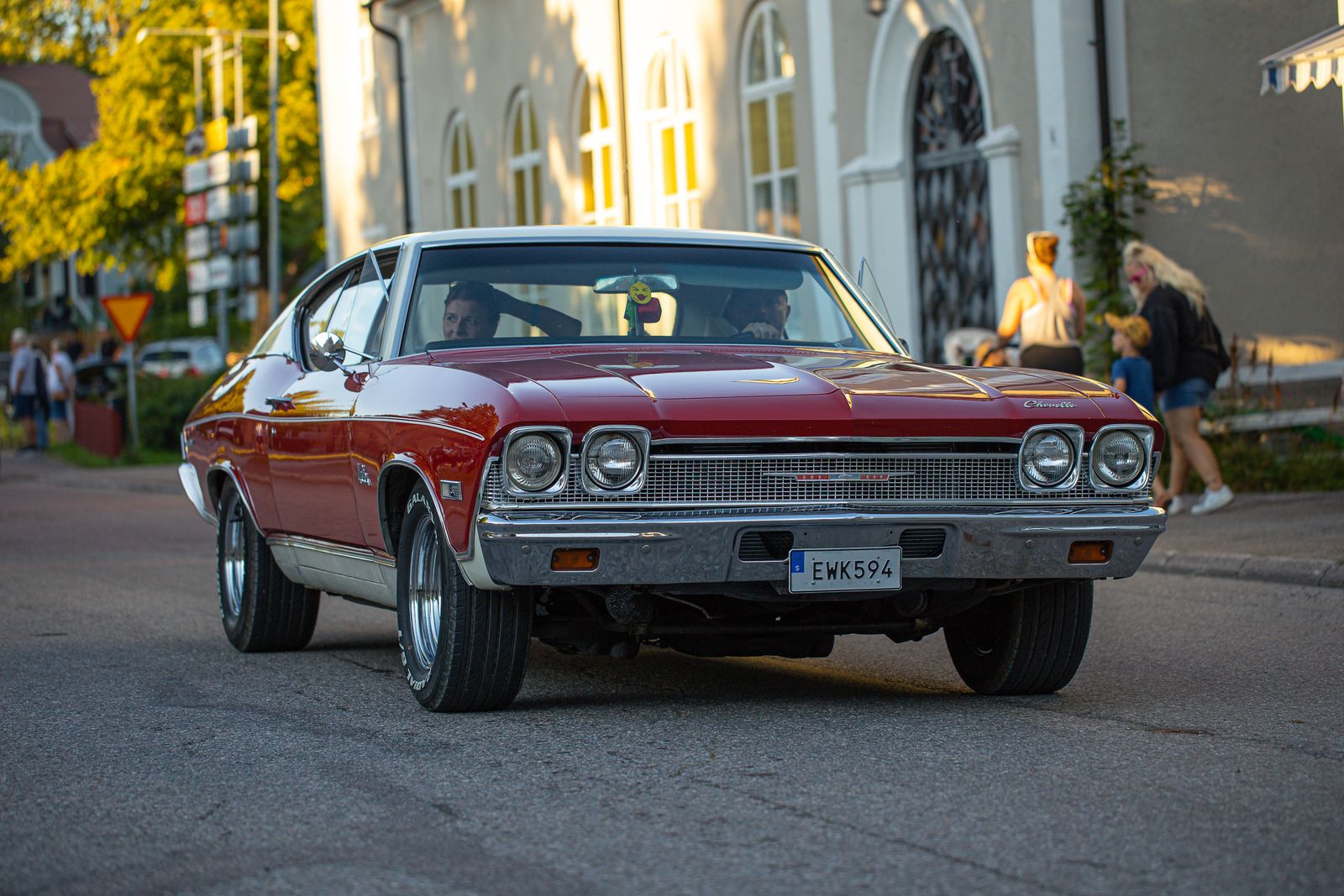 Red classic Chevrolet Chevelle coupe on an urban street