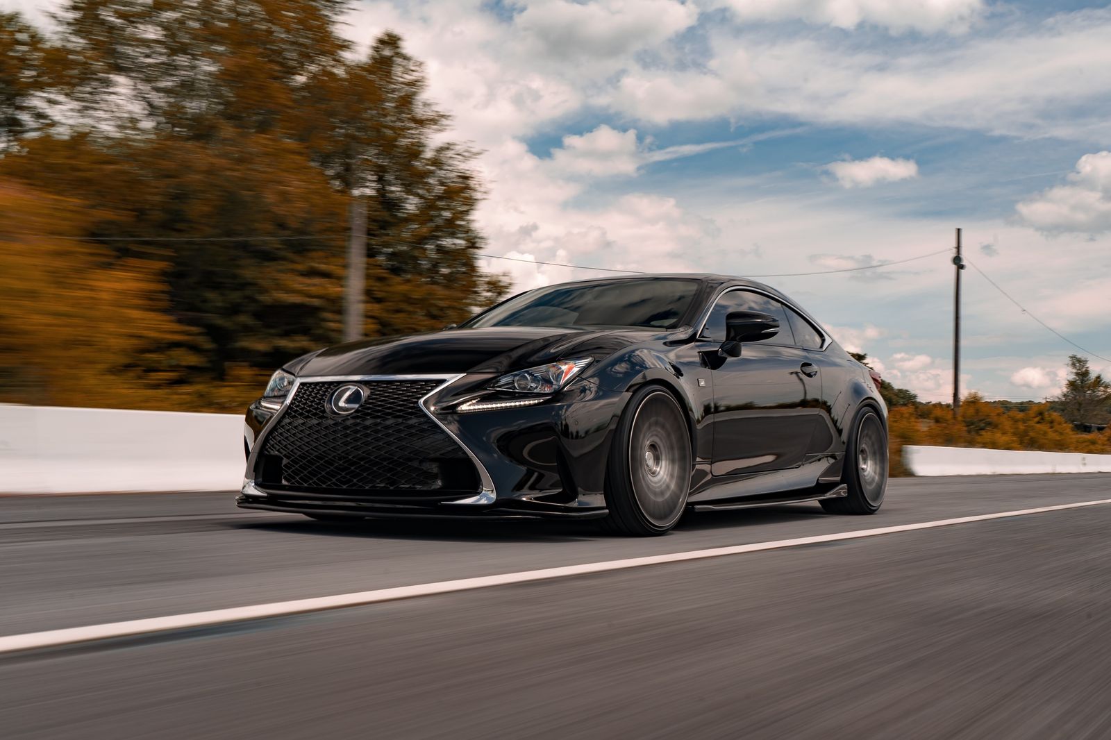 Black Lexus car driving on an open road