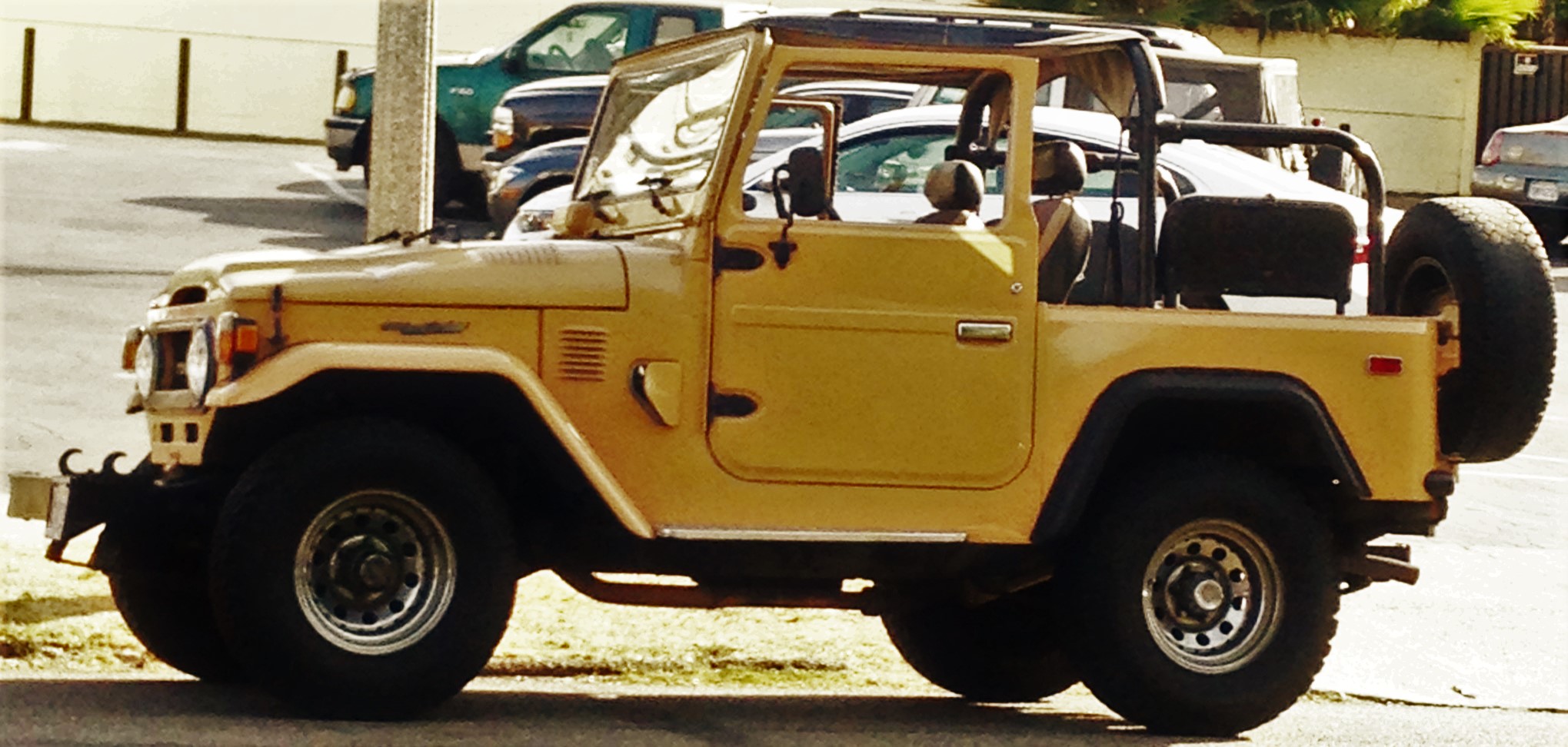 Yellow Toyota Land Cruiser FJ40 with an open roof