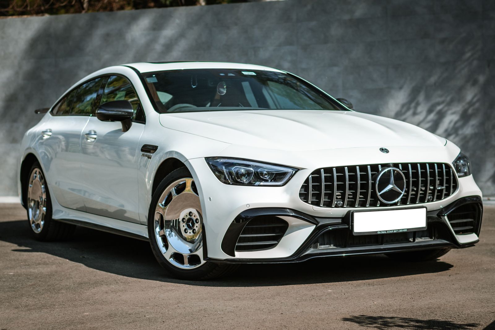 Coupé de cuatro puertas Mercedes-AMG GT blanco con llantas personalizadas