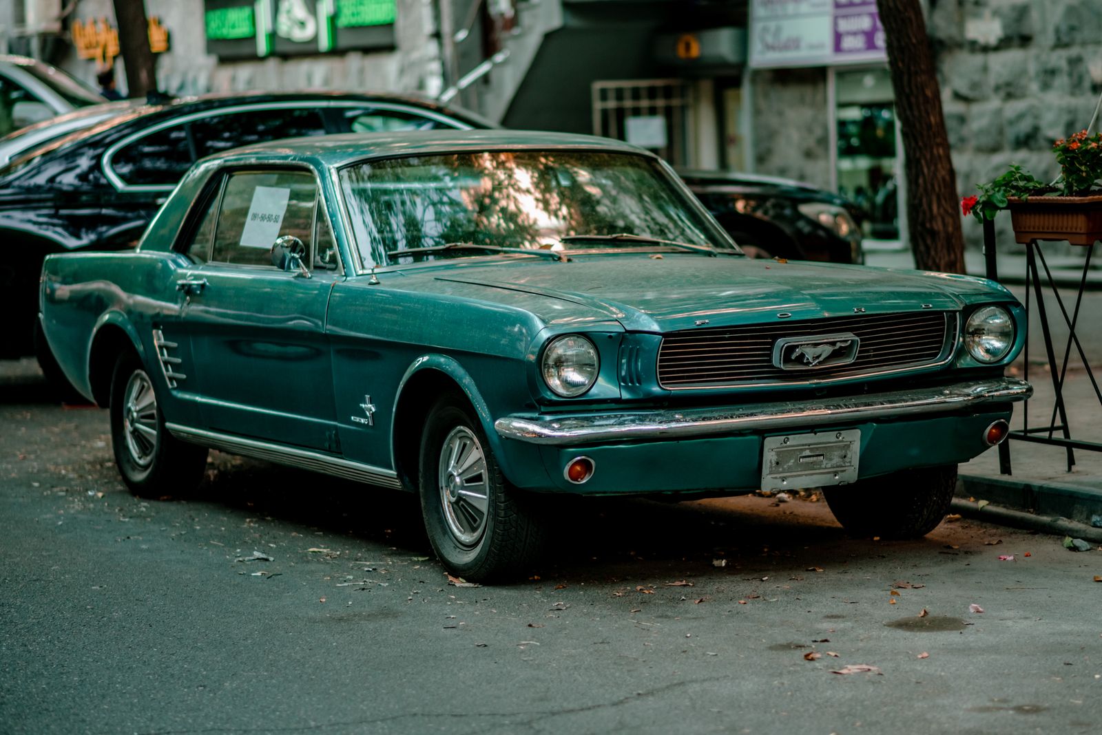 Turquoise 1960s Ford Mustang coupe on a street