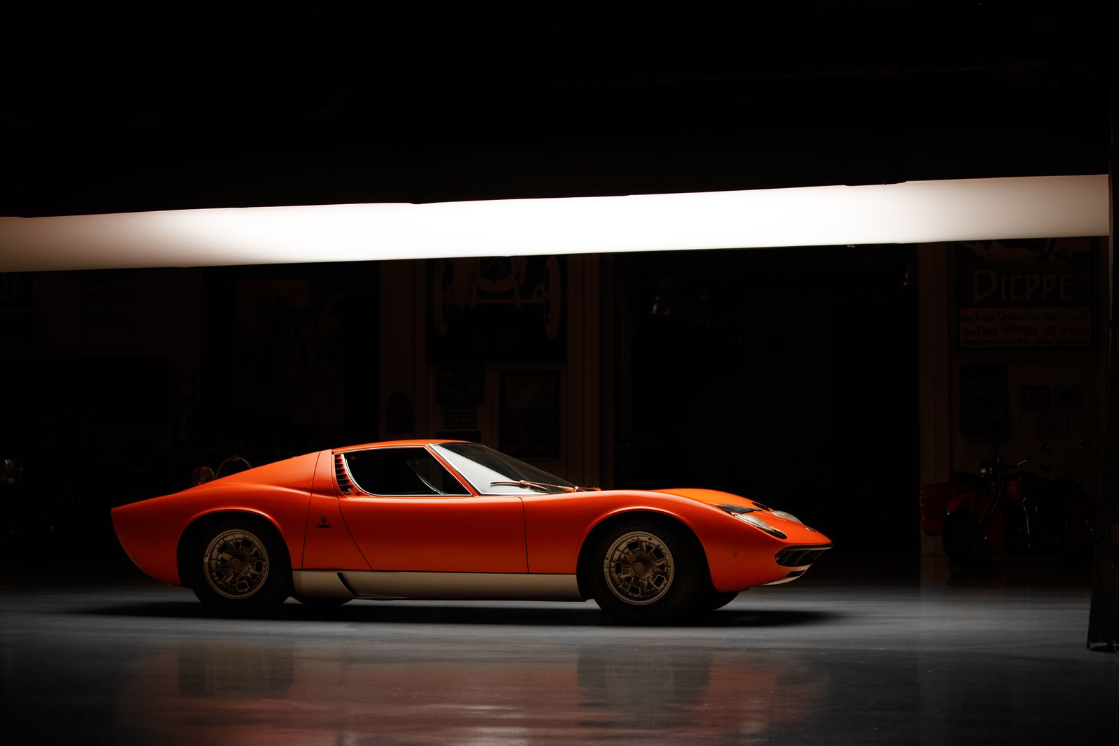 Orange Lamborghini Miura displayed in a museum