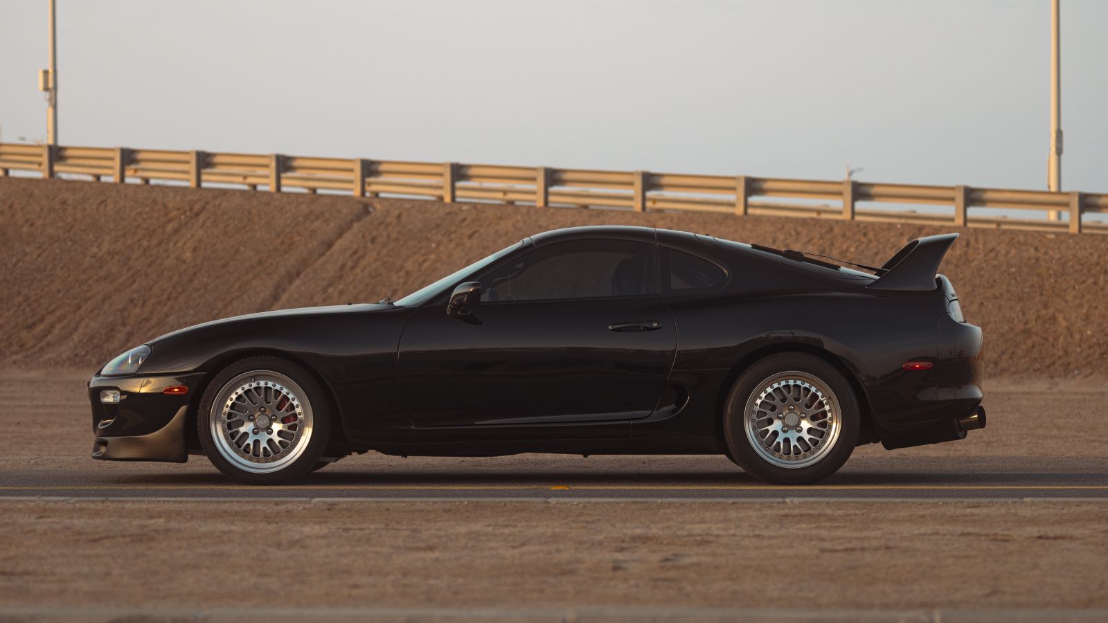 Toyota Supra A80 negro modificado visto de lado