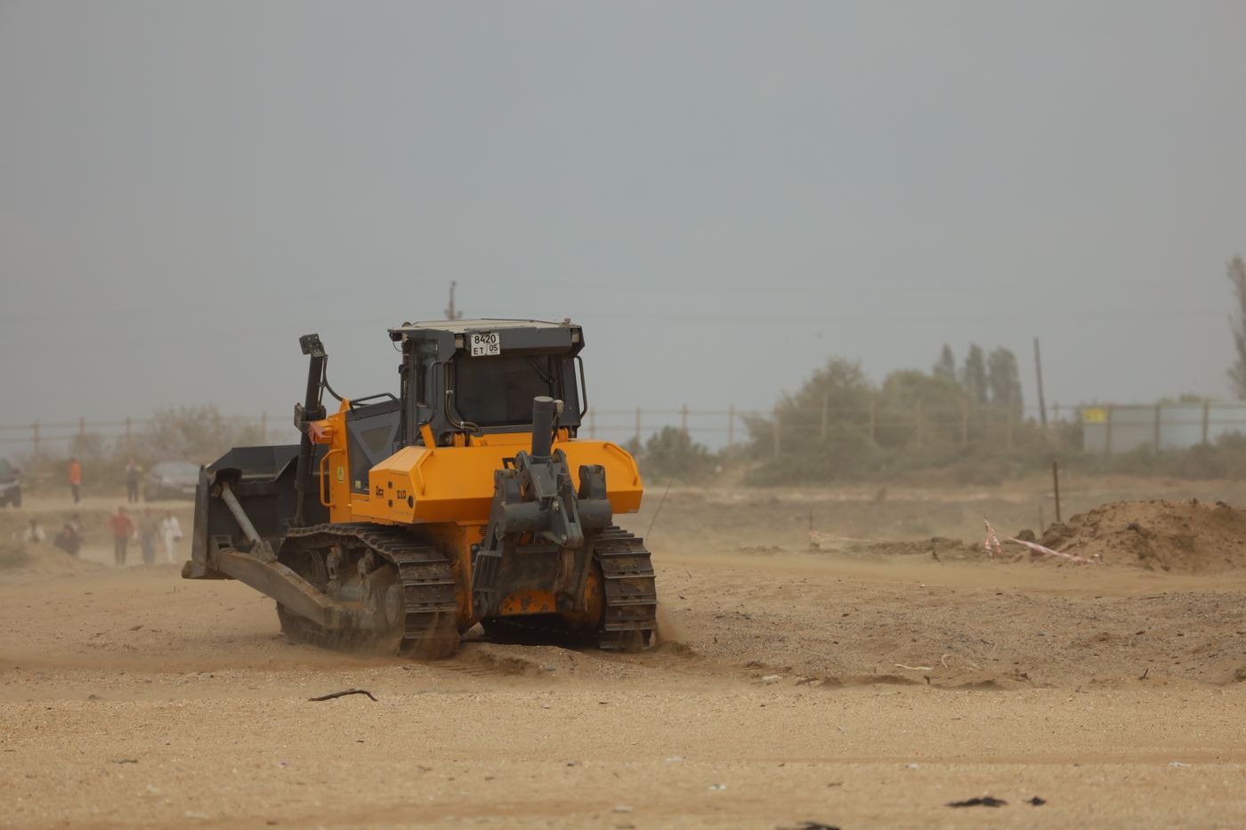 Bulldozer de cadenas trabajando en una obra de movimiento de tierras con polvo