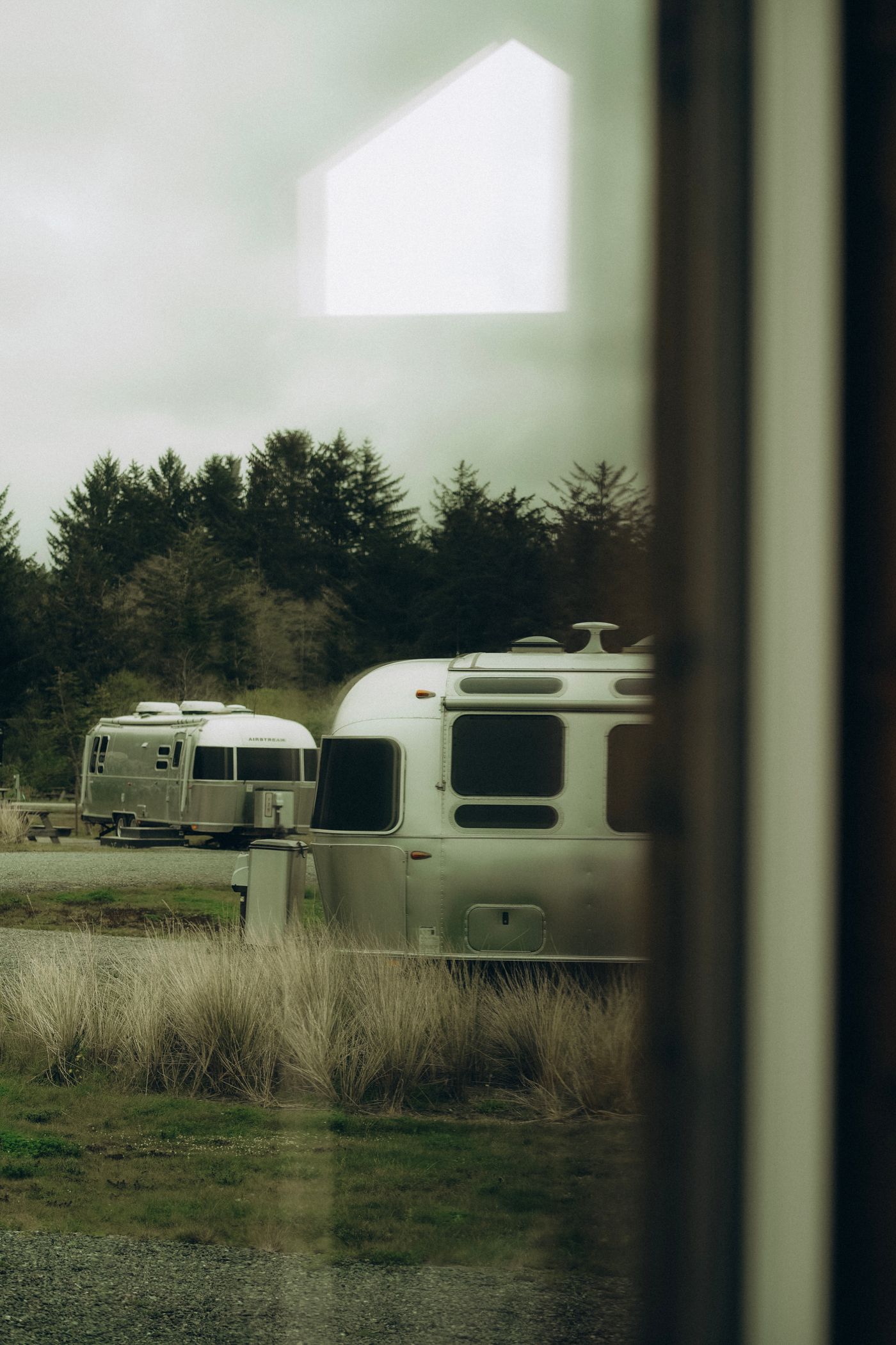 Aluminium Airstream travel trailers at a wooded campsite