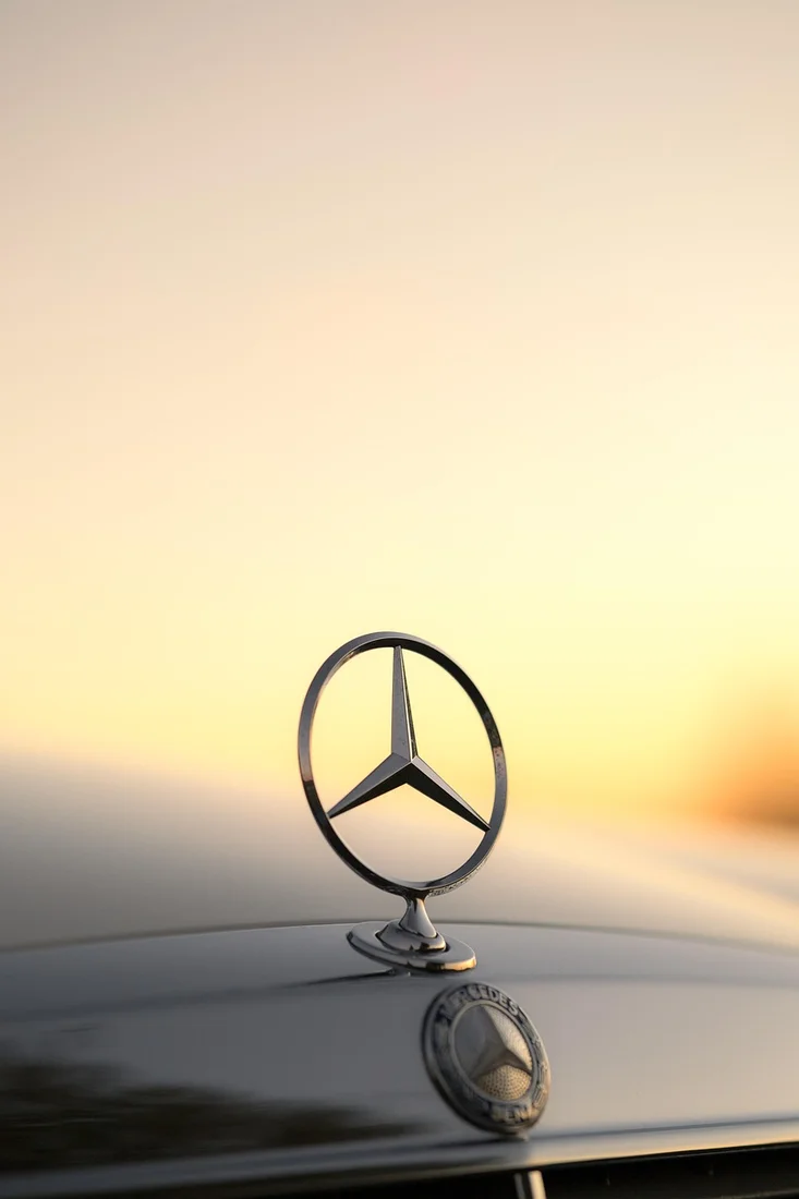 Mercedes-Benz three-pointed star at sunset