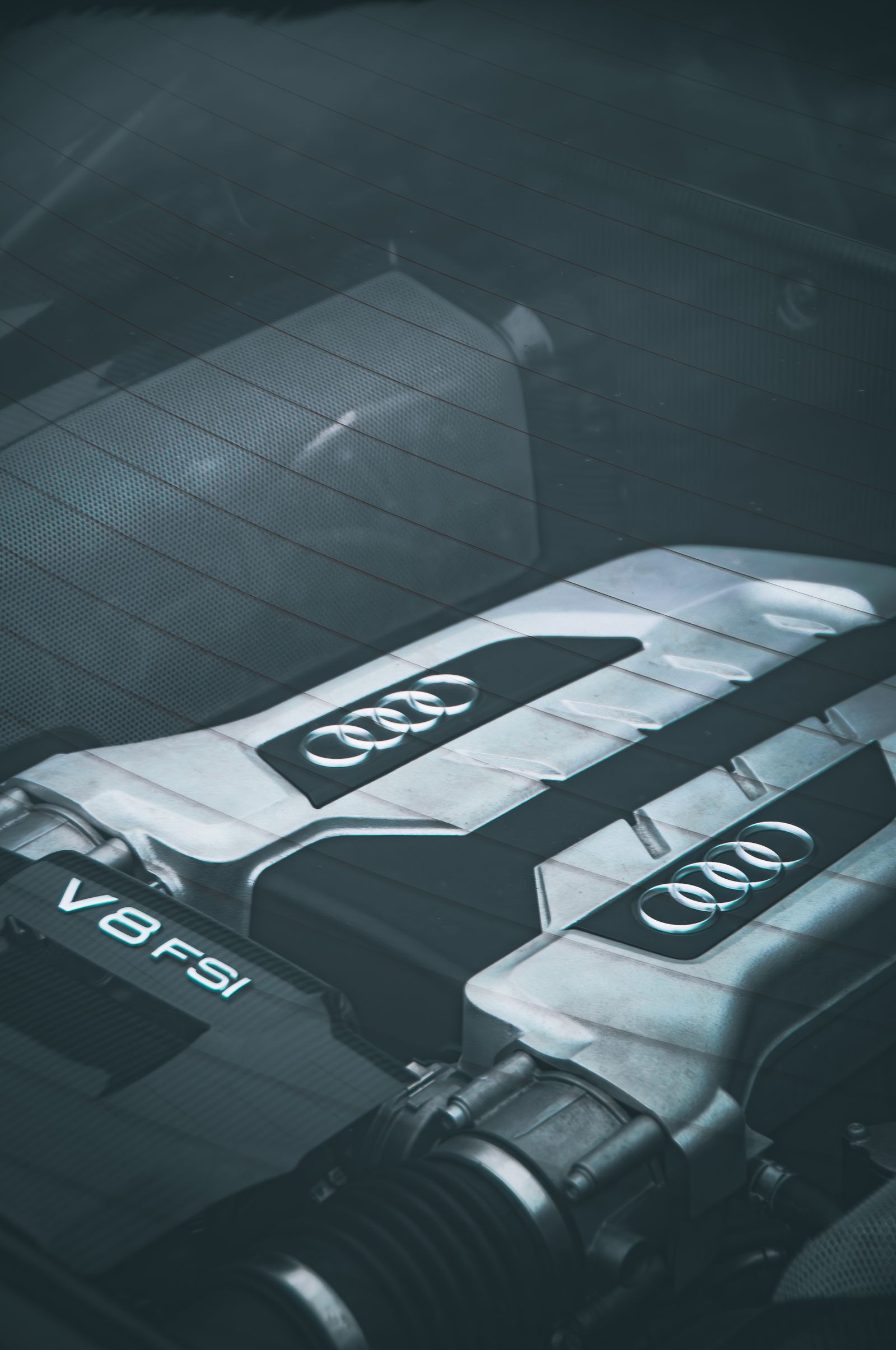 Close view of a V8 engine cover seen through a car's rear window